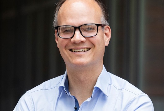 Pictured is Jan Rosenow, Director of European Programmes at the Regulatory Assistance Project, wearing a blue shirt and smiling at the camera.