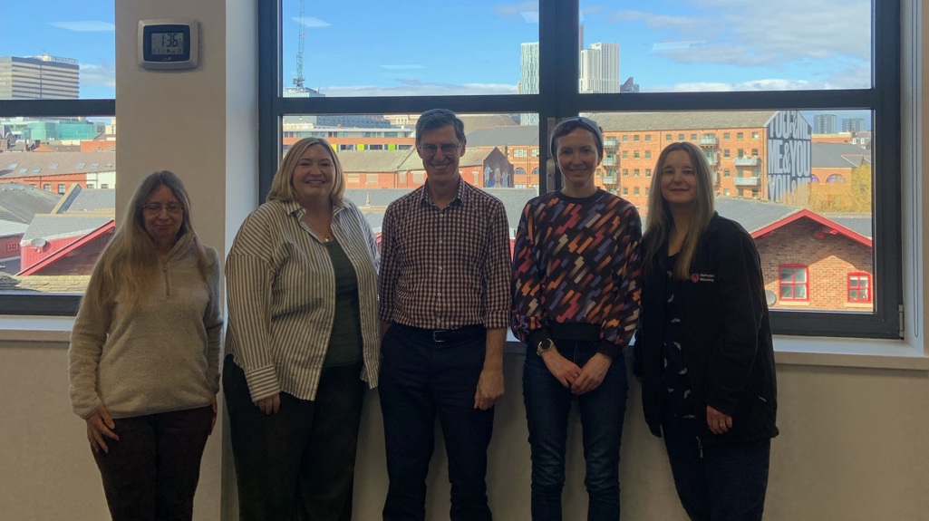 Five of our tenancy coaches standing together and smiling in front of a window 