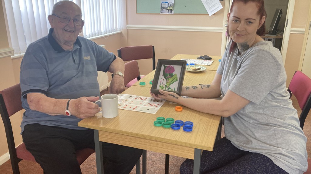 Sarah one of our volunteers with a customer who made her a piece of art