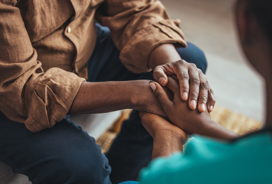 Two people holding hands in a gesture of care and support