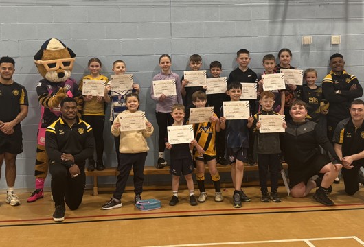 A group photo of players, coaches and youngsters holding certificates at the Castleford Tigers camp.