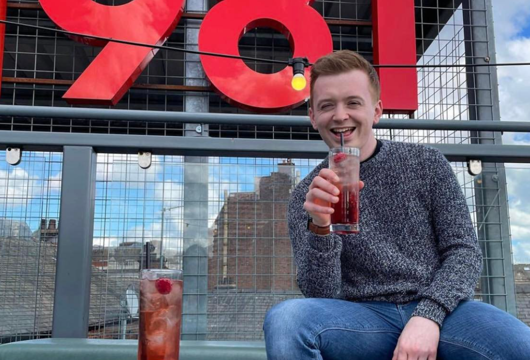 Liam Owenson having a drink at an outdoors venue
