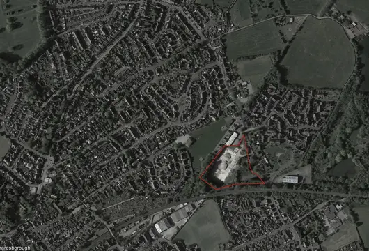 Aerial view showing an area for development of new homes outlined in red